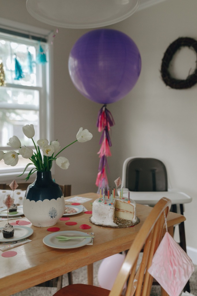 Une table décorée pour un anniversaire, avec un gros ballon et un gâteau