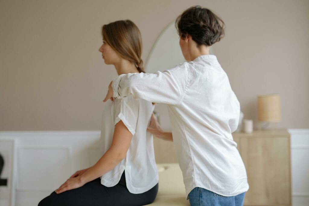 Une professionnel fait un massage à une personne assise.