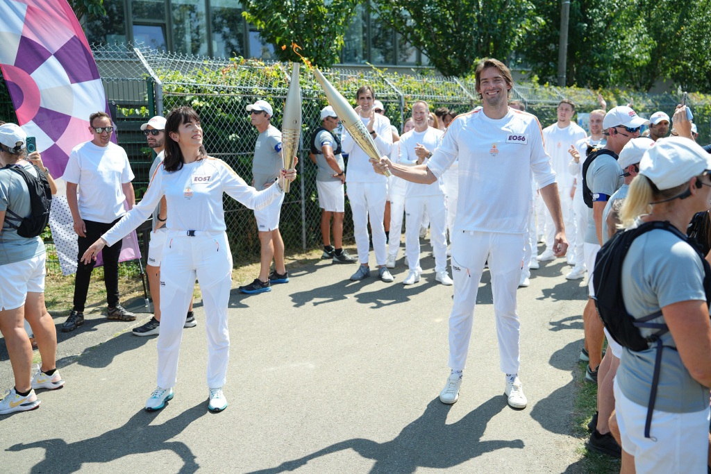 Torch kiss entre Aurélie Tourette et Camille Lacourt, relais de la flamme, Paris 2024, à Sarcelles