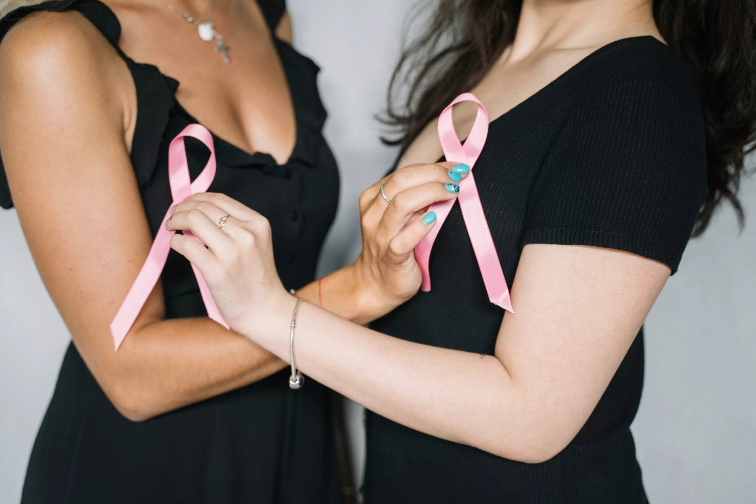 Deux femmes montrent le ruban rose de la prévention contre le cancer du sein pour Octobre Rose.