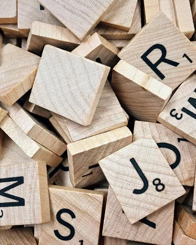 Des lettres de scrabble en bois pour illustrer les jeux pour enfants.