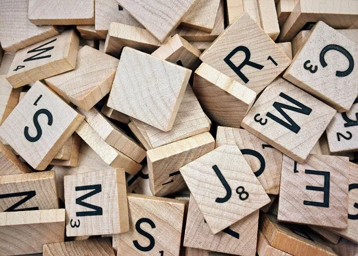 Des lettres de scrabble en bois pour illustrer les jeux pour enfants.